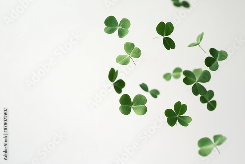 A swirl of four leaf clovers dancing gracefully in the air against a bright white background