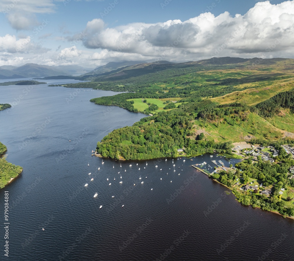 Aerial view of Loch Lomond with tranquil harbour and boats surrounded by lush hills, Glasgow, United Kingdom. Aerial view of Loch Lomond with tranquil harbour and boats surrounded by lush hills, Glasgow, United Kingdom.