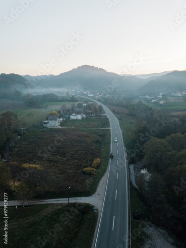 Aerial view of winding road through beautiful mountains and tranquil valley with village, Maglaj, Bosnia and Herzegovina. photo