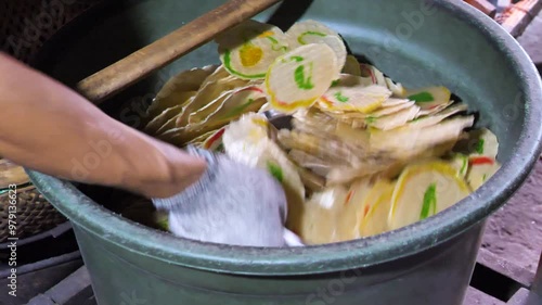 Slow-motion shot of raw krupuk being taken out of a metal basket, used for sand production snacks. Indonesia. photo