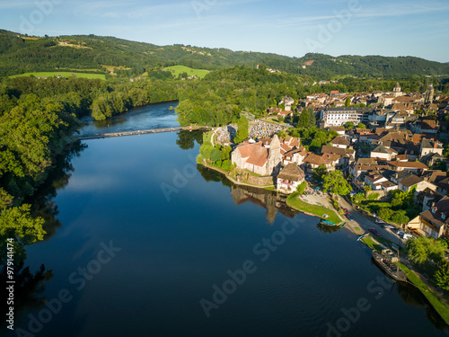 Aerial view of picturesque Beaulieu sur Dordogne village with a scenic river, lush forest, and historic buildings, Correze, France.