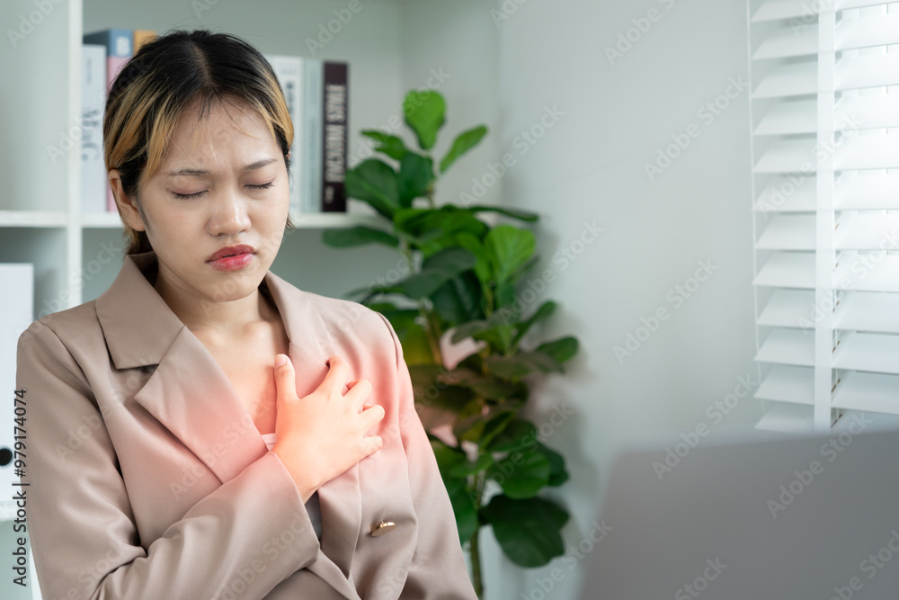 hand hold chest with heart attack symptoms, asian woman working hard have chest pain caused by heart disease, leak, dilatation, enlarged coronary heart, press on the chest with painful expression hand hold chest with heart attack symptoms, asian woman working hard have chest pain caused by heart disease, leak, dilatation, enlarged coronary heart, press on the chest with painful expression