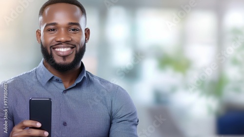 A man with a beard is smiling and holding a cell phone