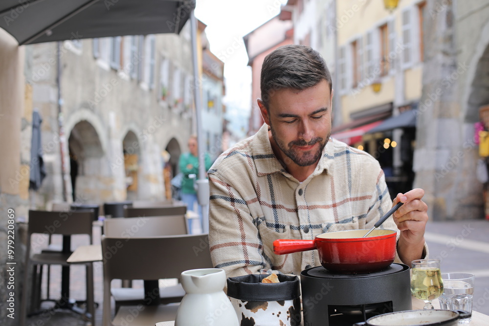 Handsome man enjoying a fondue in Europe Handsome man enjoying a fondue in Europe