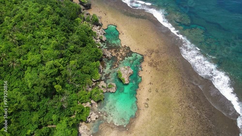 4K drone video over The Magpupungko Rock Pools on Siargao Island in The Philippines. This beautiful bright blue rock pool forms when during low tide and is a popular tourist destination on the island. photo