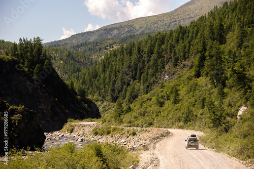 Japanese SUV moving by a road near a mountain river