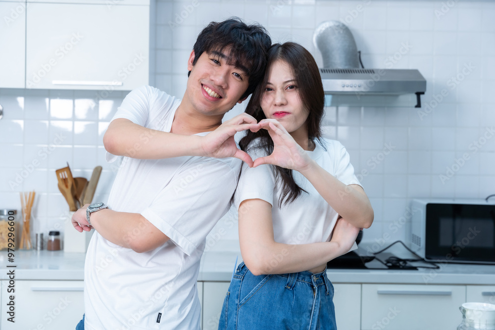 Happy portrait of loving young asian of having fun standing a cheerful heart shaped hands preparing food and enjoy cook cooking bread while standing on a kitchen Condo life or home