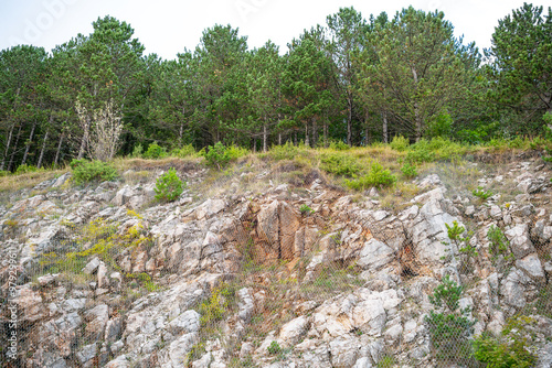 Protective metal mesh against rock fall near the mountain road