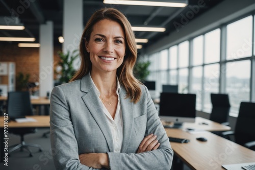 successful businesswoman standing in creative office and looking at camera while smiling