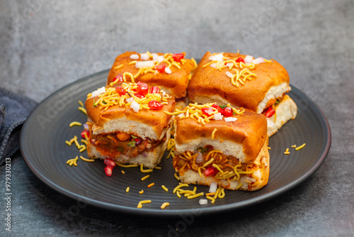 Dabeli is a spicy Indian street food made with a potato filling, tamarind chutney, and sev, served in a bun. photo