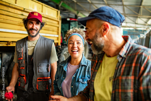 Group of diverse farmers talking in tractor shed photo