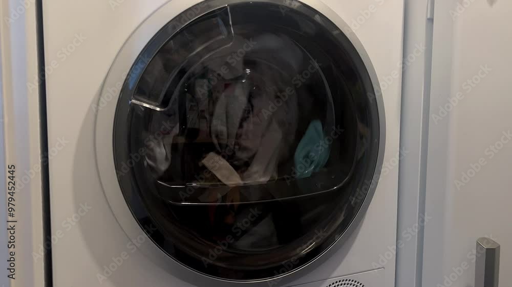 Close up of washing machine door with rotating cloths inside Close up of washing machine door with rotating cloths inside