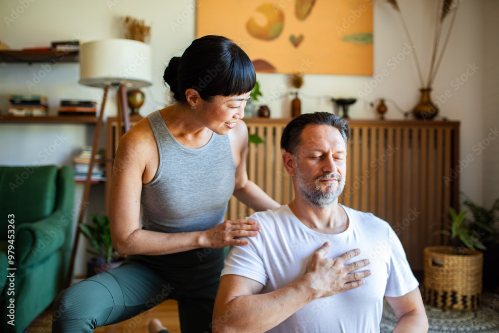 Obraz premium Couple meditating together at home on yoga mats