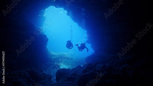 Wallpaper Mural SCUBA Divers swim into an  underwater cave from a blue entrance Torontodigital.ca