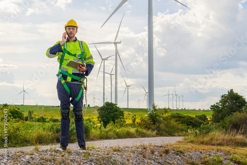 man in a safety vest is talking on a cell phone while standing in a field