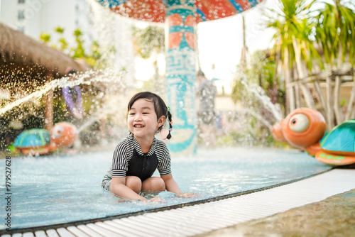 Asian adorable little girl enjoying in the pool on sunny day.