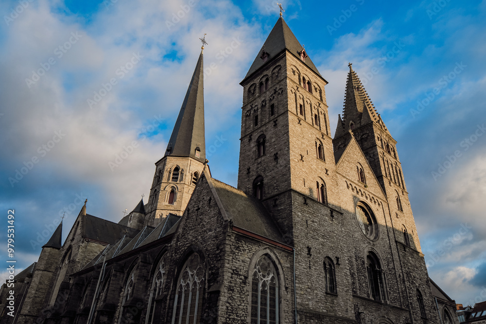 Historic architecture of Saint Bavo's Cathedral under a cloudy sky in Ghent, Belgium at dusk Historic architecture of Saint Bavo's Cathedral under a cloudy sky in Ghent, Belgium at dusk
