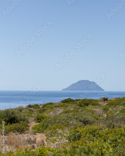 View of serene coastline with azure sea and lush vegetation, Alicudi, Eolian Islands, Italy. photo