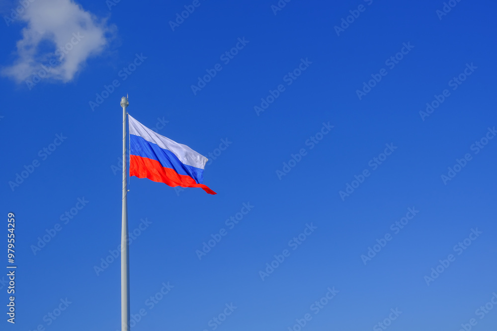A large flag of the Russian Federation on a blue sky background A large flag of the Russian Federation on a blue sky background