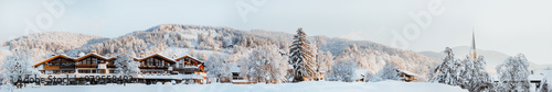 Mountain Bavarian winter landscape with a view of Bavarian houses, a church in the mountains. Winter resort. Banner.