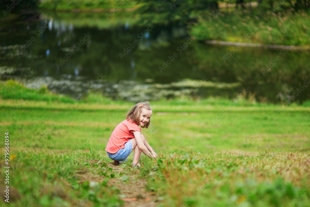 Adorable preschooler girl having fun in a green park on a summer day. Adorable preschooler girl having fun in a green park on a summer day.