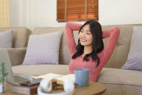 Young businesswoman sitting on the floor to relaxation and watching movie on laptop with happiness