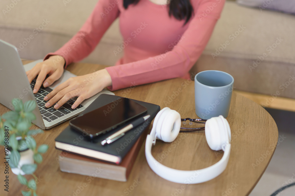 Fototapeta premium Young businesswoman thinking new project and typing business report on laptop while working at home