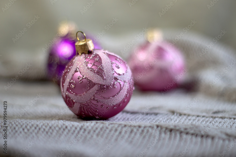 Beautiful lilac Christmas balls ornaments with patterns in on a cozy light knitted background, close up Beautiful lilac Christmas balls ornaments with patterns in on a cozy light knitted background, close up