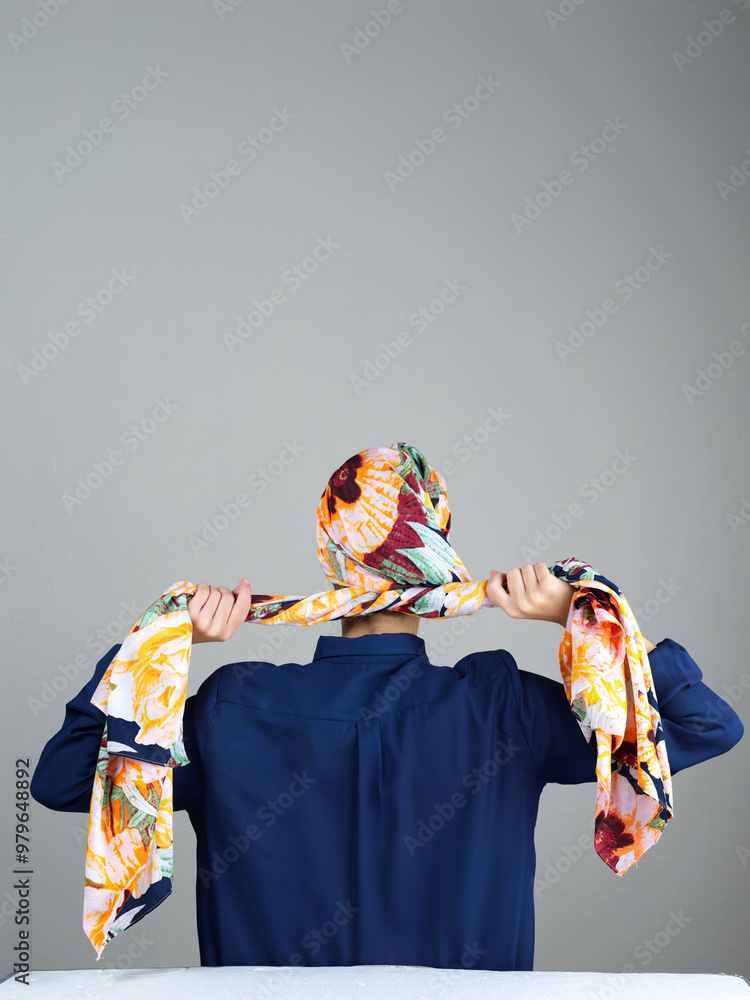 Naklejka premium Hijab, scarf and back of woman in studio for islamic fashion, arabic culture and modest clothes. Raya, eid Mubarak celebration and elegance with muslim person on grey background for oriental design