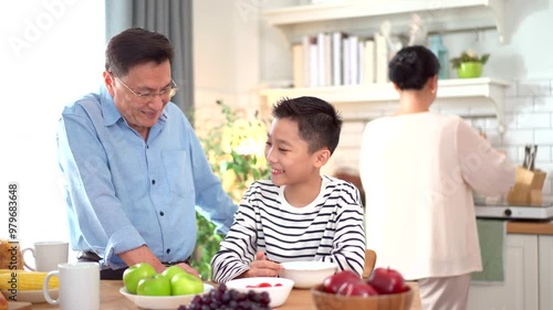 Happy Asian family with farther, mother, and son are enjoy eating a breakfast together in kitchen,  photo