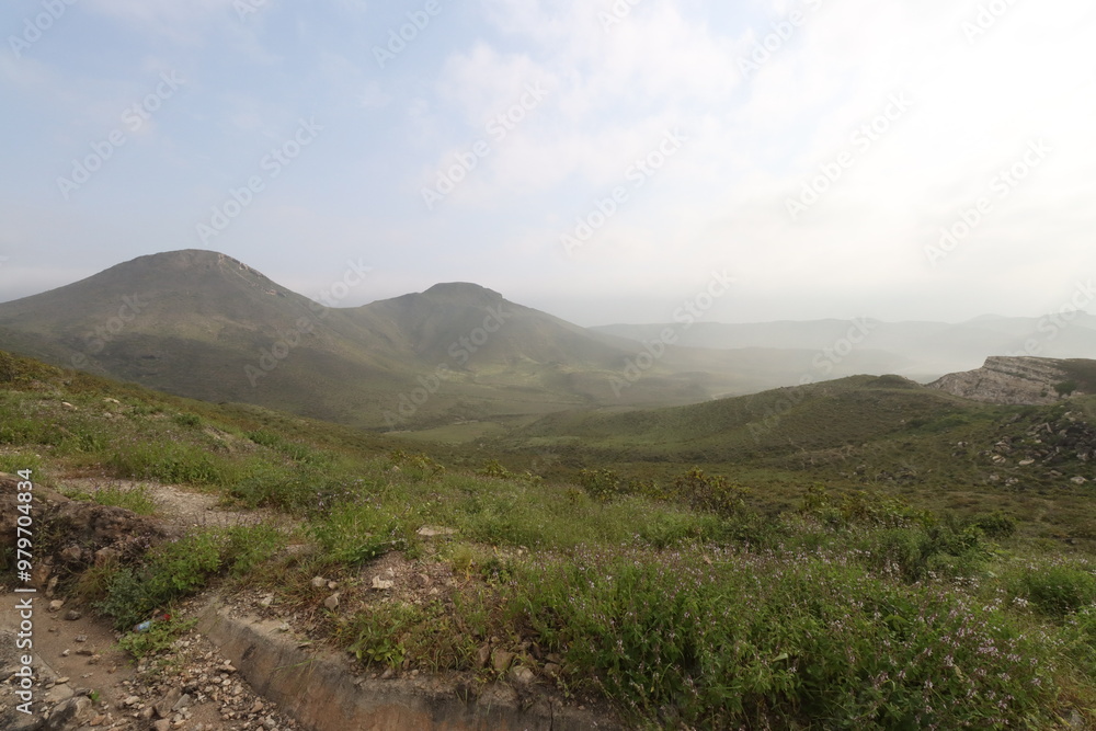 mountains with green grass and cloudy sky in oman mountains with green grass and cloudy sky in oman