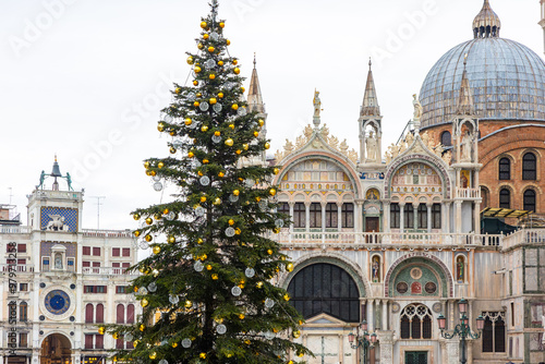 San Marco square in Venice, Italy with festive holiday season decorated illuminated Christmas tree, lights, plaza doge palace and piazza