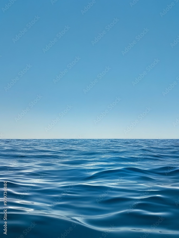 Fototapeta premium A serene seascape with a crystal-clear blue sky meeting the tranquil ocean horizon. The gentle waves, vastness, and clear blue hues evoke a sense of peace, serenity, and the beauty of nature.