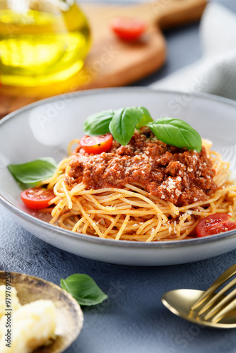 Traditional italian food - spaghetti bolognese with fresh basil leaves and parmesan cheese
