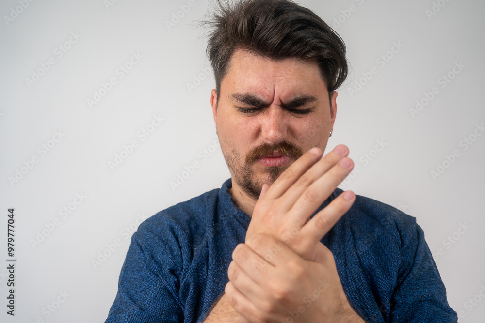 Close-up of young bearded man at computer working place and experiencing pain and discomfort in wrist joint. Tendonitis, synovitis, osteoarthritis, sprain, rheumatoid arthritis concept Close-up of young bearded man at computer working place and experiencing pain and discomfort in wrist joint. Tendonitis, synovitis, osteoarthritis, sprain, rheumatoid arthritis concept