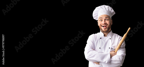 Bakerman. Excited Baker Chef Posing With Dough Rolling Pin Standing Over Black Studio Background. Panorama, Free Space photo