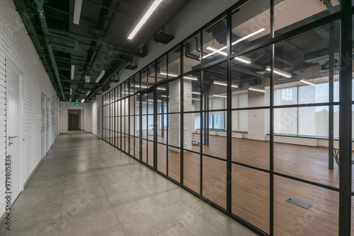 An open space of a modern office with panoramic windows and glass partitions. The room is decorated in loft style. photo