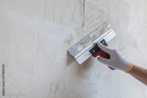 The concept of puttying the wall is leveled with a spatula.