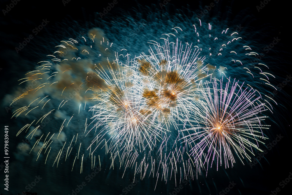Fototapeta premium Multicolored figures silver and blue bright sparks of fireworks on the black sky. Horizontal photo.