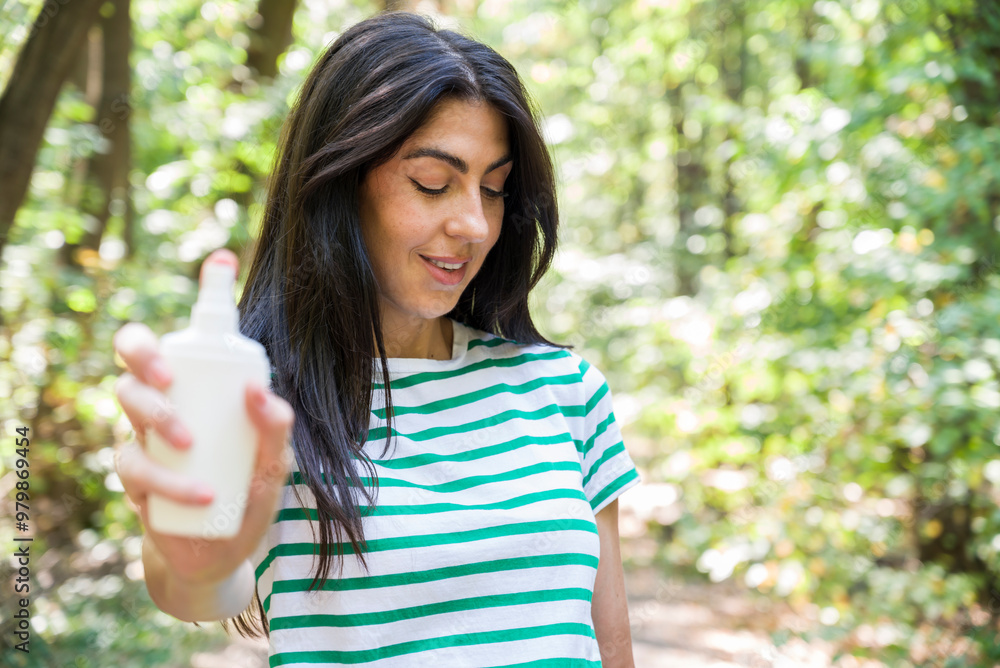 Woman spraying mosquito repellent on skin in the nature Woman spraying mosquito repellent on skin in the nature