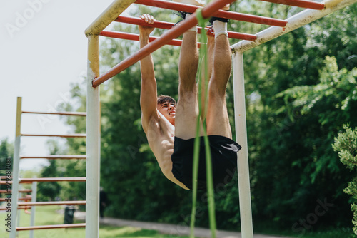 A fit and strong male athlete working out on monkey bars in a park on a sunny day, showcasing his fitness and strength. photo