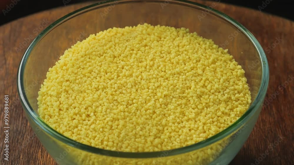 Couscous golden grain in a transparent bowl rotates in a circle Couscous golden grain in a transparent bowl rotates in a circle