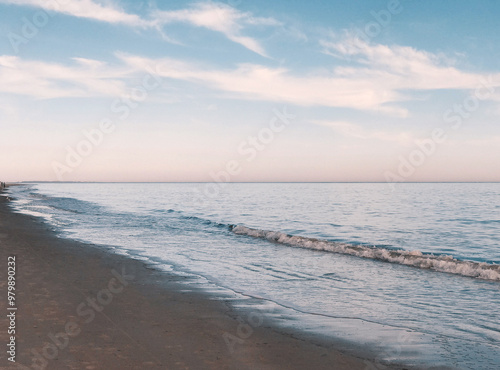 Peaceful beach at dusk with blue and pink skies
