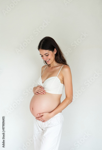 Young pregnant woman in a simple white outfit, smiling warmly and cradling her belly, against a plain white background.
Free Download Young pregnant woman in a simple white outfit, smiling warmly and cradling her belly, against a plain white background.
- GFXLoad