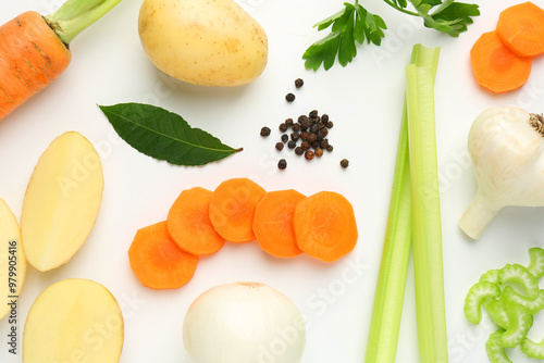 Pieces of fresh ripe carrots, vegetables and spices on white background, flat lay