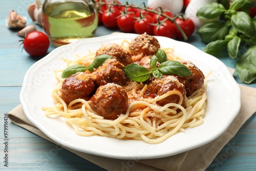 Delicious pasta with meatballs and ingredients on light blue wooden table, closeup