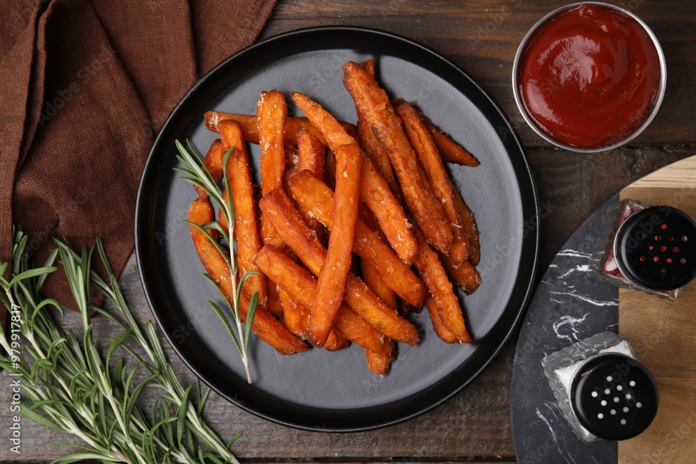 Sweet potato fries, rosemary and ketchup on wooden table, flat lay Sweet potato fries, rosemary and ketchup on wooden table, flat lay
