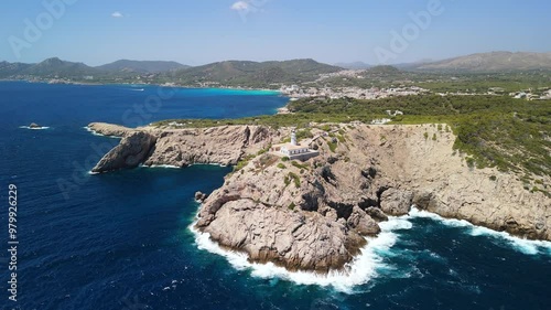 Aerial view of Lighthouse in Mallorca on a rocky coastline on a sunny day, drone