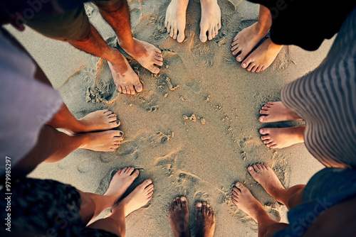 Diversity, feet and beach with circle huddle at party hangout for summer, vacation or holiday in nature together. Above friends, sand and celebration with people, bonding and traveling by seashore photo