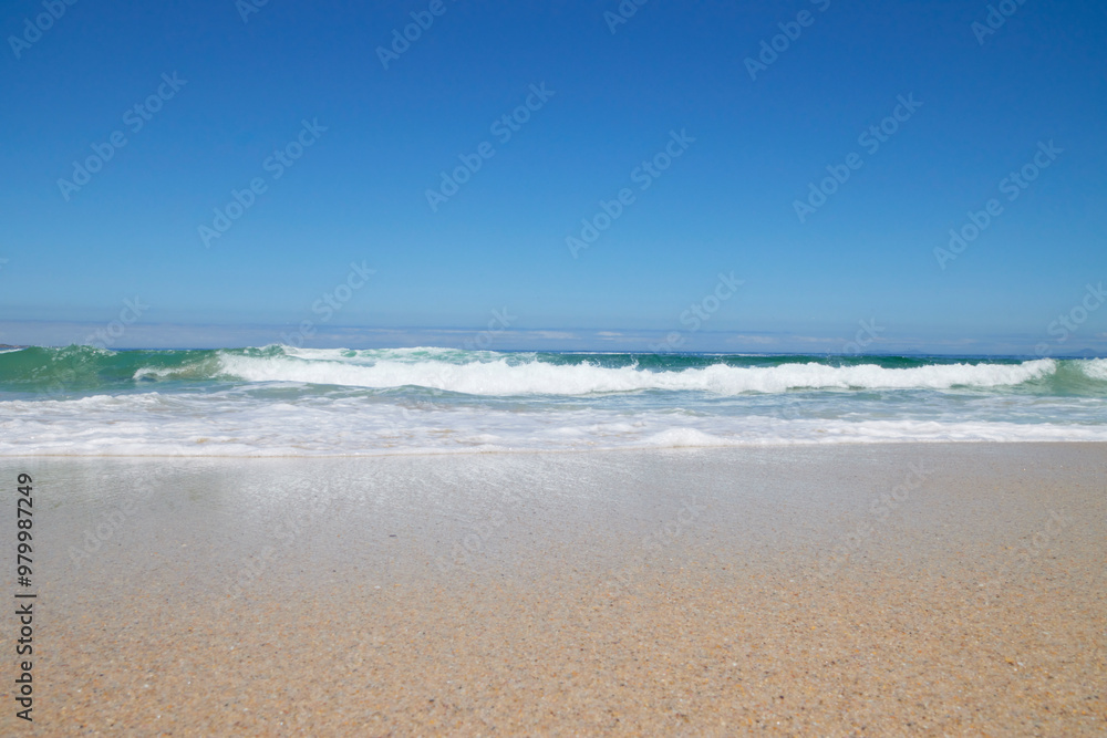 Welle am Strand bei blauem Himmel